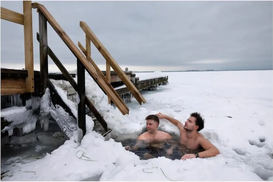 To vinterbadere i isvågen ved trappen